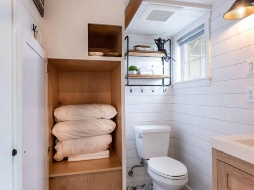 a bathroom with a toilet and a pile of towels at Enchanting Retreat in the heart of Redwoods in Guerneville