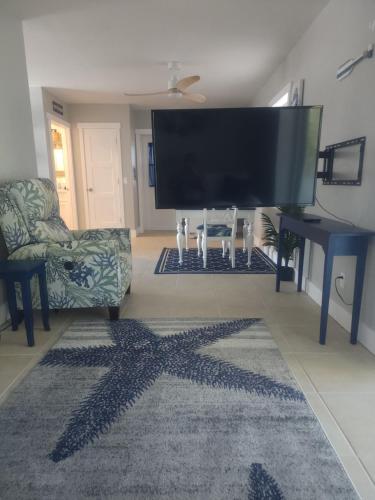 ein Wohnzimmer mit Fernseher und Sternenteppich in der Unterkunft So Coastal! Pet friendly and free early check in! in Fort Myers