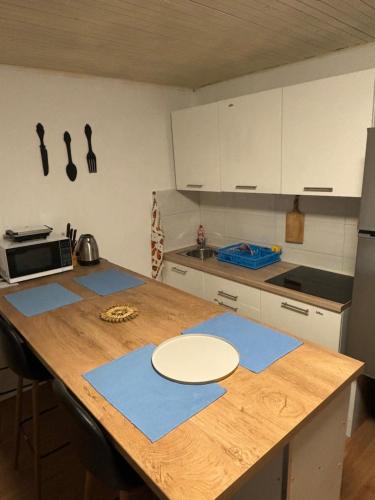 a kitchen with a wooden table with blue mats on it at Studio i Apartman Ema in Rijeka