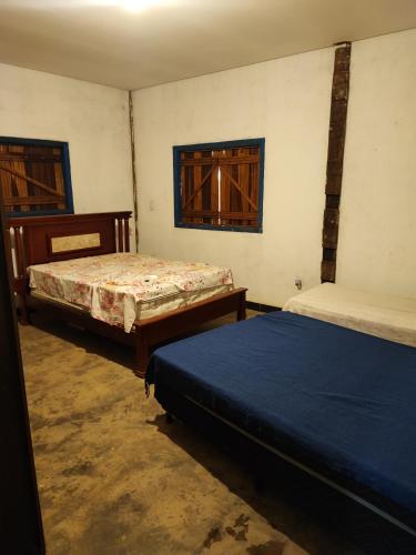 um quarto com duas camas e duas janelas em Sitio Cheiro Do Campo em Jaboticatubas