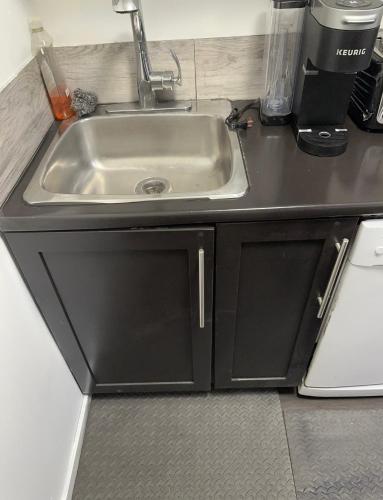 um balcão de cozinha com um lavatório na cozinha em Comfortable 3 Bed Basement Unit em Winnipeg