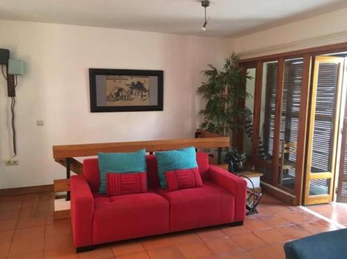 ein rotes Sofa im Wohnzimmer in der Unterkunft Soltroia Beach House in Carvalhal