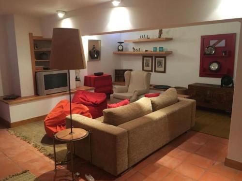 ein Wohnzimmer mit einem Sofa und einem TV in der Unterkunft Soltroia Beach House in Carvalhal