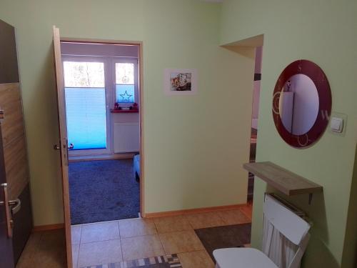 a bathroom with a toilet and a door with a mirror at Apartament Alias in Wisła