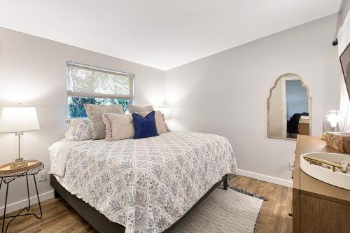 a bedroom with a bed and a window and a mirror at Dreamprint Delmar in Naples