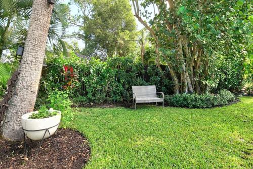 a chair sitting in a yard next to a tree at Dreamprint Delmar in Naples