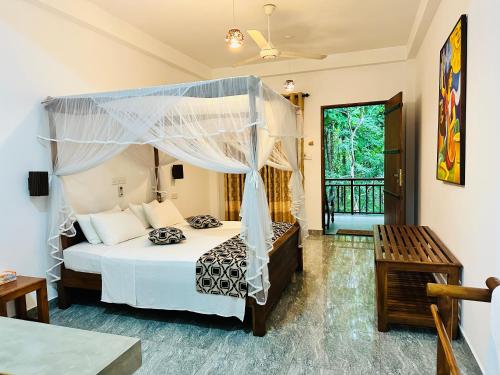 a bedroom with a bed with a canopy at Nature House in Udawalawe