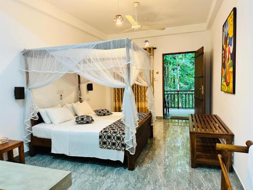 - une chambre avec un lit à baldaquin dans l'établissement Nature House, à Uda Walawe