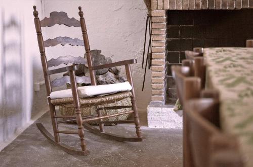 a cat sitting in a rocking chair in front of a fireplace at Mas Illa de Riu - Auténtica Masía del Delta del Ebro con capacidad para 20 personas - Deltavacaciones in Sant Jaume d'Enveja