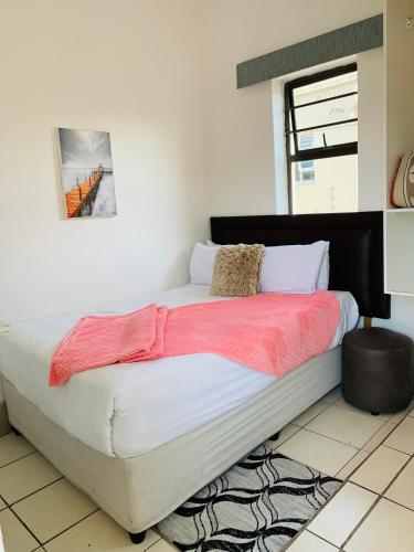 a bedroom with a large bed with a red blanket at Beach View B&B in East London