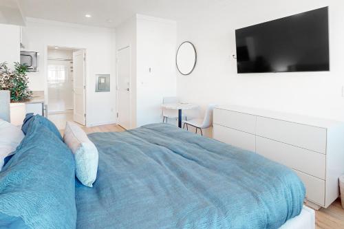 ein Schlafzimmer mit einem großen Bett und einem TV an der Wand in der Unterkunft Mellow on Meadow Mile 2B in Fraser