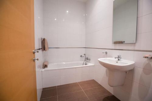y baño blanco con lavabo y bañera. en Spinola Bay Large 1 Bedroom Apartment for 4, en San Julián