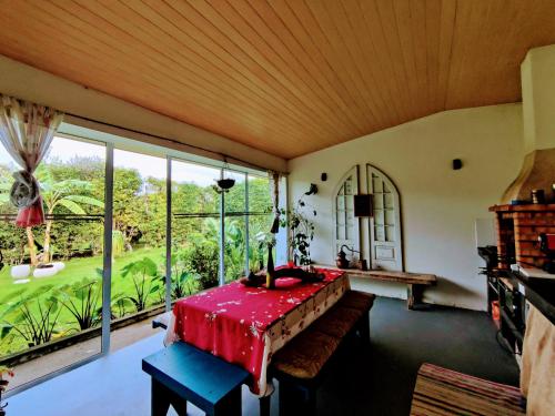 a dining room with a table and a large window at Quinta Minuvida in Rabo de Peixe
