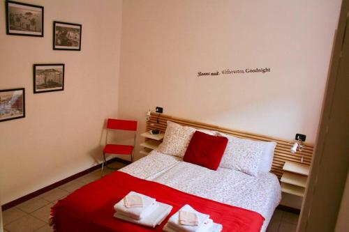 a bedroom with a red and white bed and a chair at GEZELLIG APPARTEMENT MET GEDEELTELIJK MEERZICHT in Acquaseria