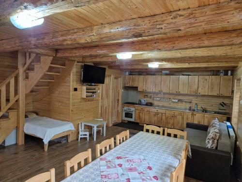 une chambre avec une table et une cuisine avec des murs en bois dans l'établissement Kispatak Vendégház, à Ciumani