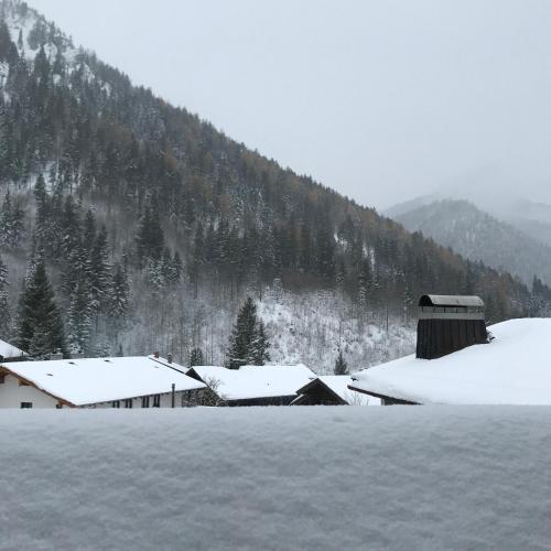 a snow covered field with houses and a mountain at Gästehaus Hotel Maria Theresia in Schliersee