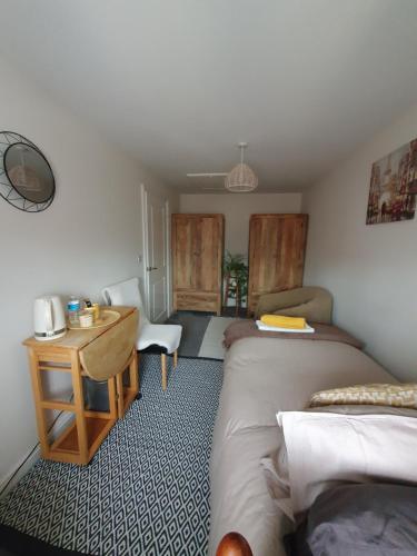 a room with two beds and a table and a desk at Bright room with private toilet and shared bathroom, suitable for a professional 