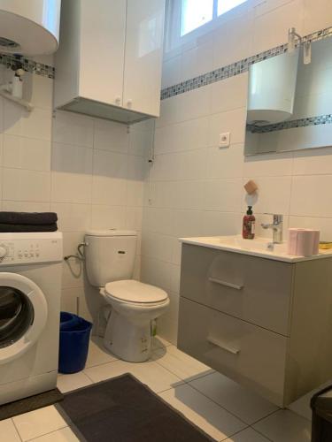 ein Badezimmer mit einem WC, einem Waschbecken und einer Waschmaschine in der Unterkunft STUDIO MOLIERE in Montrouge