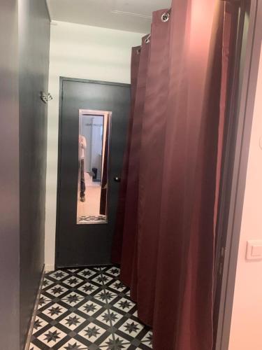 einen Flur mit Tür und eine Person im Spiegel in der Unterkunft STUDIO MOLIERE in Montrouge