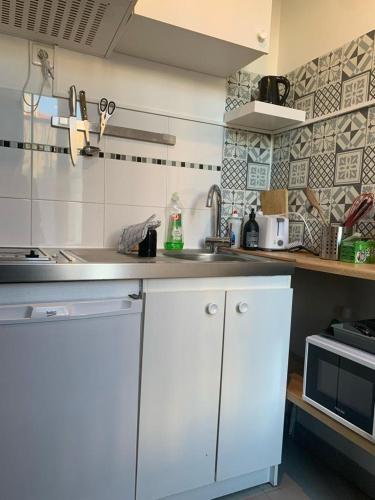 cocina blanca con fregadero y microondas en STUDIO MOLIERE, en Montrouge