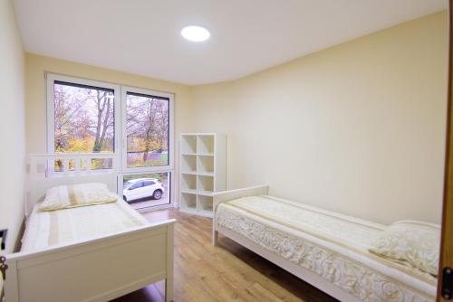 a bedroom with two beds and a window at Wunderschöne, neue gebaute 2023 Apartments Aurelija in Reutlingen