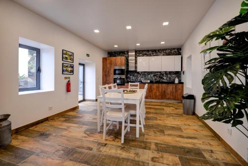Faja GrandeにあるFontinha Terrace View Houseのテーブルと椅子のあるキッチンとダイニングルーム