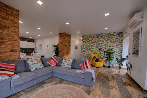 a living room with a gray couch and a wall at Fontinha Terrace View House in Faja Grande