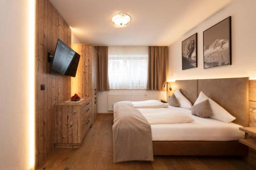 Habitación de hotel con cama y TV en Brugger's Ferienwohnungen en Fulpmes