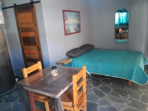 Zimmer mit einem Bett, einem Tisch und einem sidx sidx in der Unterkunft La casita de Pablo in Santa Teresita