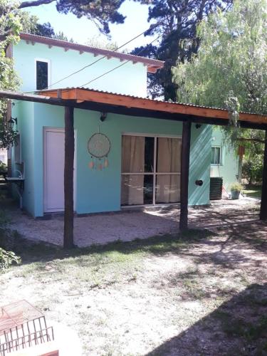 a house with a garage with a roof at La casita de Pablo in Santa Teresita