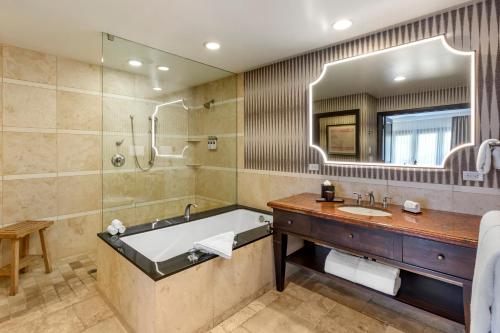 a bathroom with a tub and a sink and a mirror at Omni Scottsdale Resort & Spa at Montelucia in Scottsdale