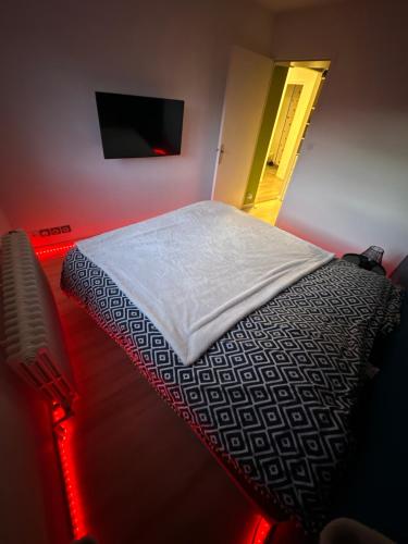 a bedroom with a bed and a tv on a wall at Appartement proche de centre ville in Rodez