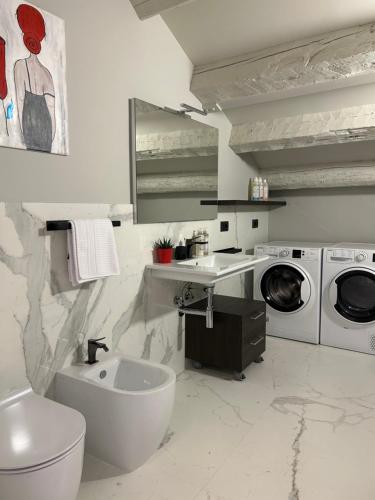 een badkamer met een wastafel en een wasmachine bij Casa Romano Suites in Trieste