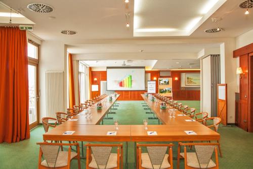 a large conference room with long tables and chairs at SEETELHOTEL Nautic Usedom Hotel & Spa das Hotel für Wellness & Genuss auf Usedom in Ostseebad Koserow