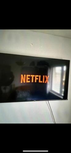 Ein Schild, auf dem steht, dass Netflix auf einer Mikrowelle ist. in der Unterkunft Deluxe Double Bed With Private Mordern Shower & Smart TV in Clydebank