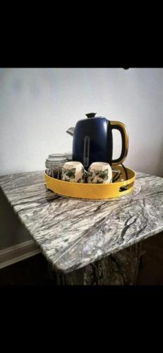 um bule de chá num prato numa mesa em Deluxe Double Bed With Private Mordern Shower & Smart TV em Clydebank