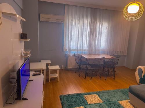 ein Wohnzimmer mit einem Tisch, Stühlen und einem TV in der Unterkunft Lavina Apartments in Istanbul