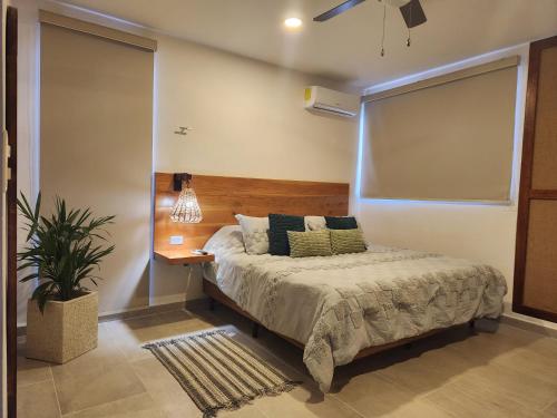 a bedroom with a bed with a wooden headboard at Comfortable private apartment AC near Montejo - Las Huayitas in Mérida