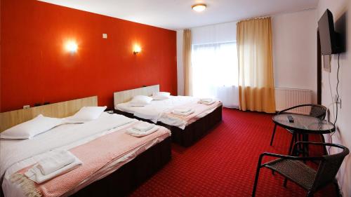 ein Hotelzimmer mit 2 Betten und einem Tisch in der Unterkunft Pensiunea Montan din Bran,sat Simon SPA indoor in Bran