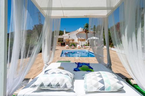 1 dormitorio con cama y piscina en Villa La Macera by Villa Plus, en Frigiliana