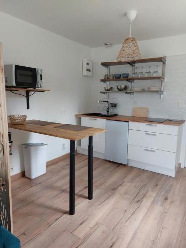 cocina con mesa de madera en una habitación en Charmant studio tout équipé, en Les Sorinières