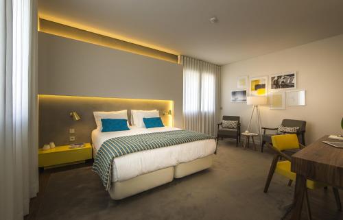 Somewhere - Estoril Guesthouse في استوريل: فندق غرفه بسرير ومكتب وغرفة