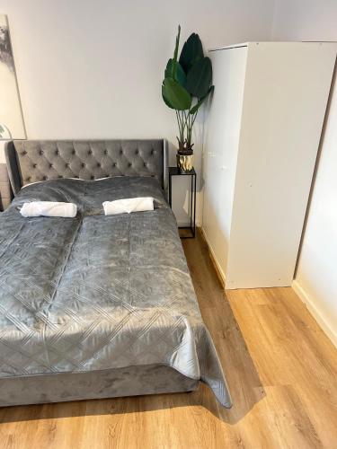 um quarto com uma cama grande e uma colcha cinzenta em Kölner City Apartment direkt am Zentrum Nähe Hbf em Colônia