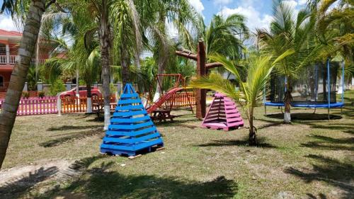 un parque con 3 parques infantiles con palmeras en Casa en la playa puerto cortes, en Puerto Cortés