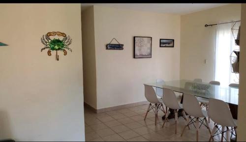 uma sala de jantar com uma mesa de vidro e cadeiras em Casa en la playa puerto cortes em Puerto Cortes