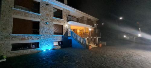 a building with blue lights on the side of it at night at Casa Buda Conors & Spa in Foz