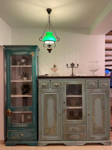 a green cabinet in a room with a chandelier at Apartament Yannis in Alba Iulia