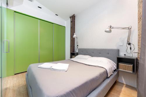 a bedroom with a large bed with green cabinets at LA CATOLICA GUEST HOUSE in Granada
