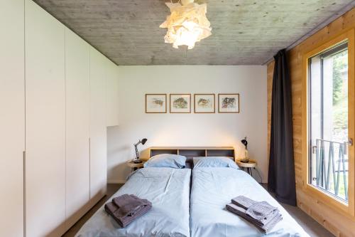 a bedroom with a bed and a chandelier at Haus Burgermeister Wohnung Schiesshorn in Arosa