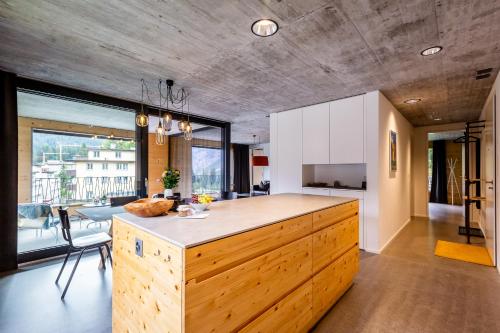 a kitchen with a wooden island in the middle of a room at Haus Burgermeister Wohnung Schiesshorn in Arosa